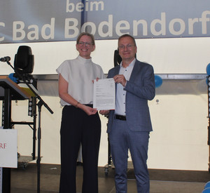 Staatssekretärin Simone Schneider mit dem Sinziger Bürgermeister Andreas Geron bei der Bescheidübergabe. 