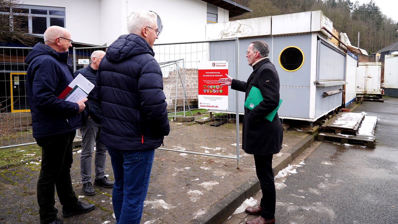 Innenminister Michael Ebling (r.) bei der Bescheidübergabe vor der Kita Wibbelstätz mit dem Bürgermeister der Verbandsgemeinde Altenahr (Landkreis Ahrweiler), Dominik Gieler (M.), und dem Ortsbürgermeister der Gemeinde Hönningen, Jürgen Schwarzmann (l.).